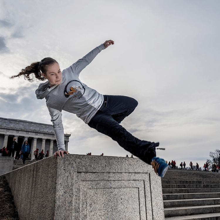 A person doing parkour in front of the Lincoln Memorial